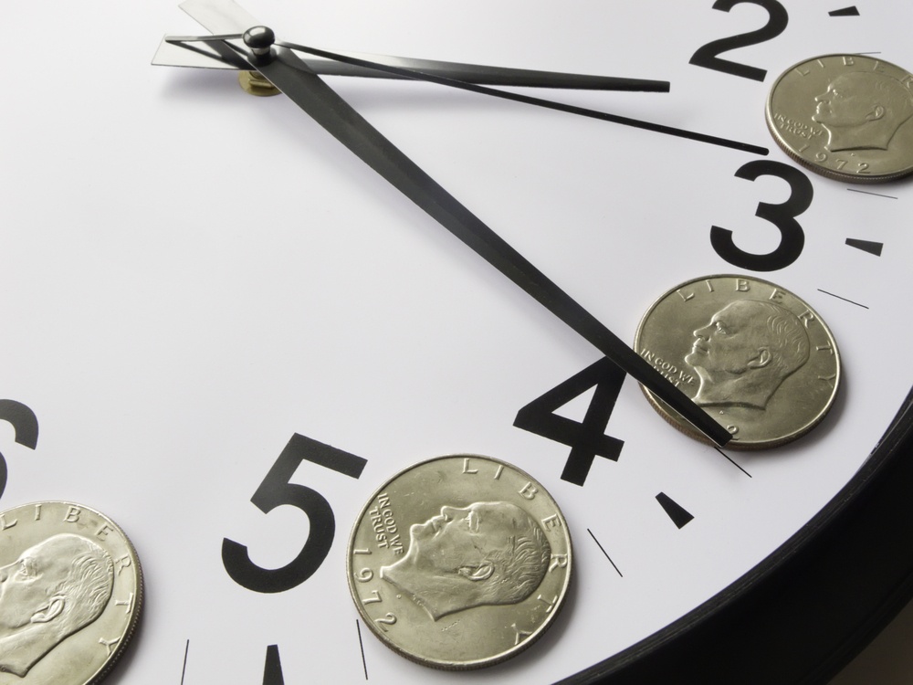 Concept of time is money Eisenhower dollar coins on face of analog clock.jpeg